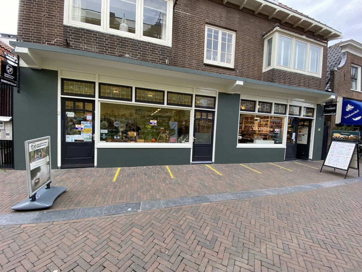 Volledig geschilderde winkelgevel van ’t Kaashuys in Zoetermeer, voorzien van strak schilderwerk aan houten kozijnen, ramen en deuren. De winkelpui heeft een klassieke uitstraling met donkergroene en witte accenten.