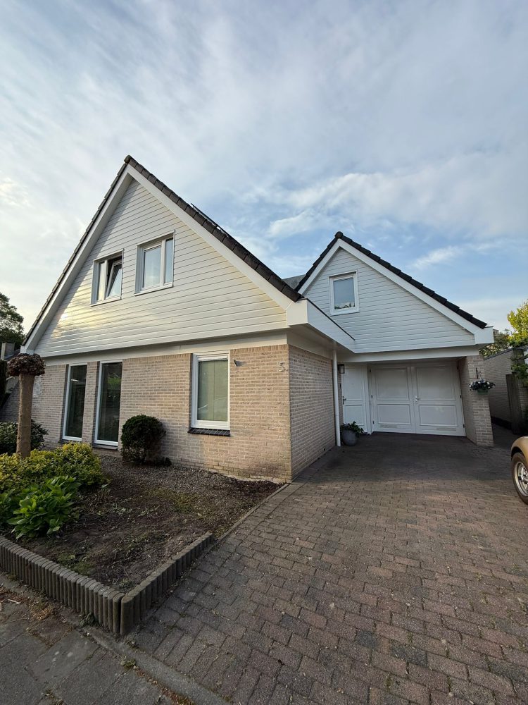 Buitenschilderwerk aan een moderne vrijstaande woning met witte gevelbetimmering en lichte baksteen, uitgevoerd door Verweij Schilderwerken uit Zoetermeer.